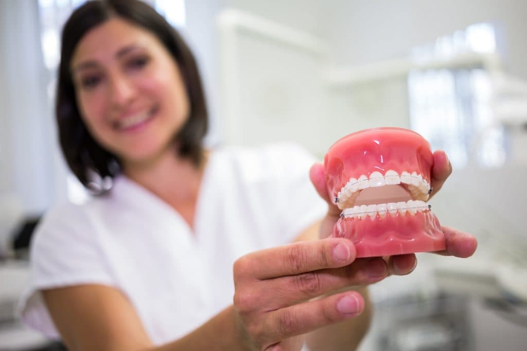 Dentista mostrando una prótesis dental removible